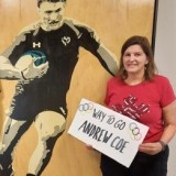 Nancy Coe in front of picture of her Olympic athlete son Andrew